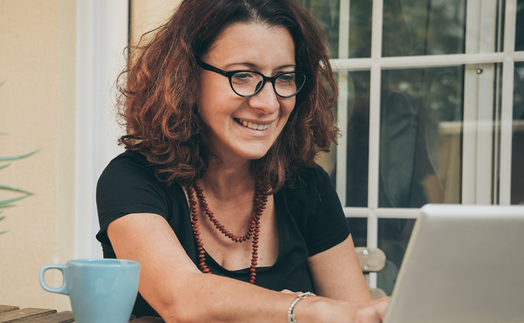 A photograph of a lady using a laptop